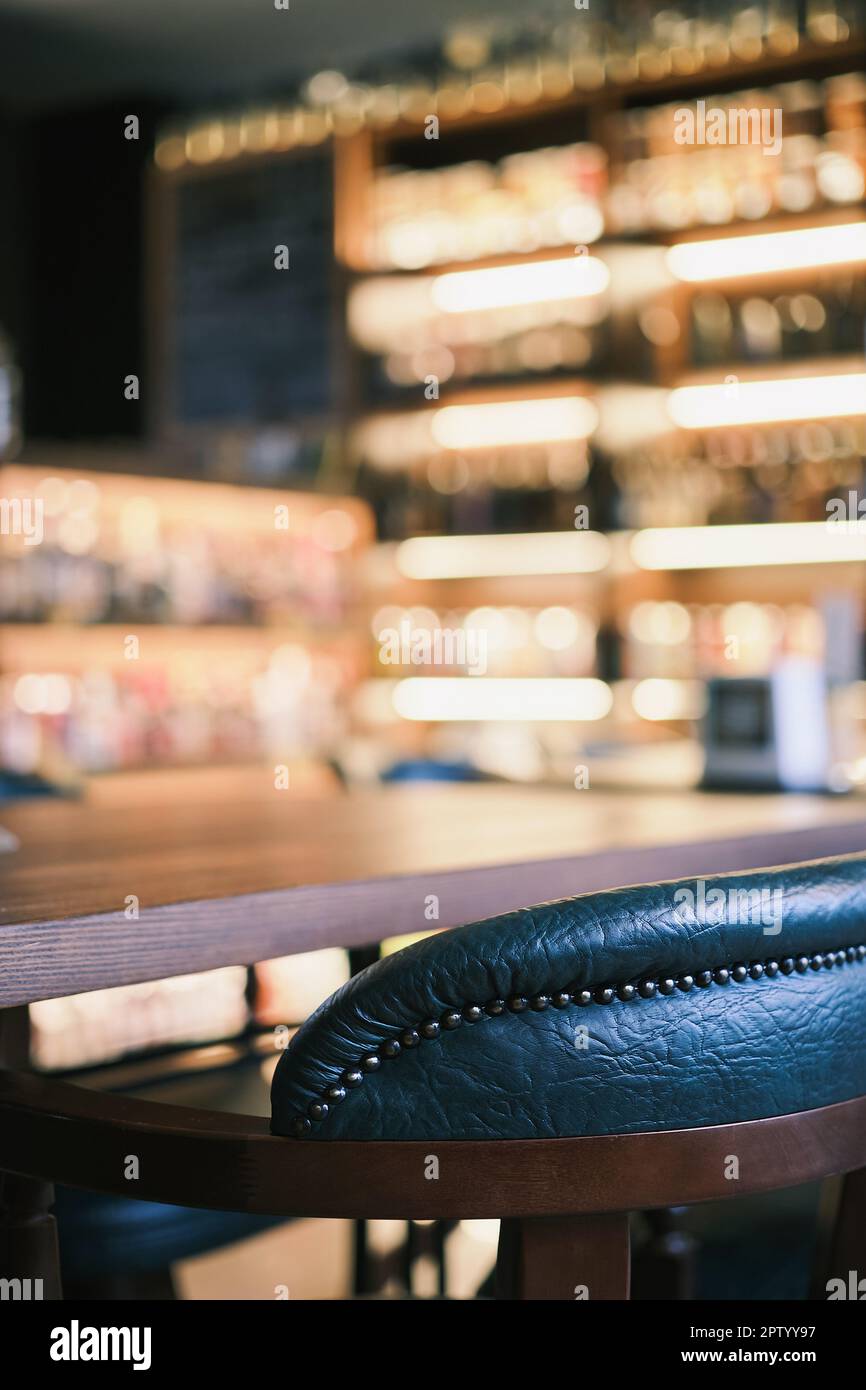 Scatto verticale, primo piano sulle sedie verdi del bar al banco. Messa a fuoco selettiva per primo piano. Vista bar, sfocatura, idea decorazione bar o foto per interni Foto Stock