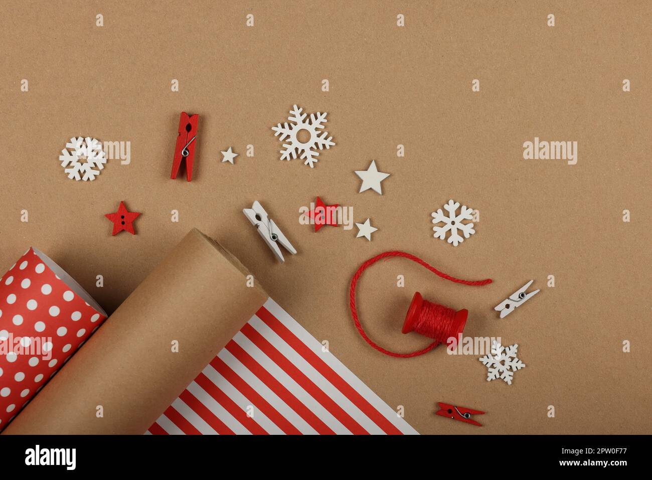 Primo piano imballaggio e imballaggio regali di Natale con carta rossa e marrone, tavolo vista dall'alto, piatto Foto Stock