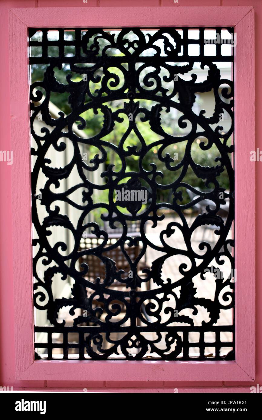 Struttura in legno rosa con design in ferro battuto Foto Stock