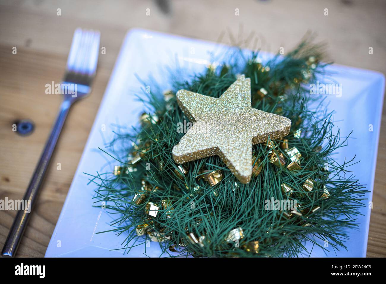 Stella di decorazione di Natale su un piatto, con forchetta e coltello. Foto Stock