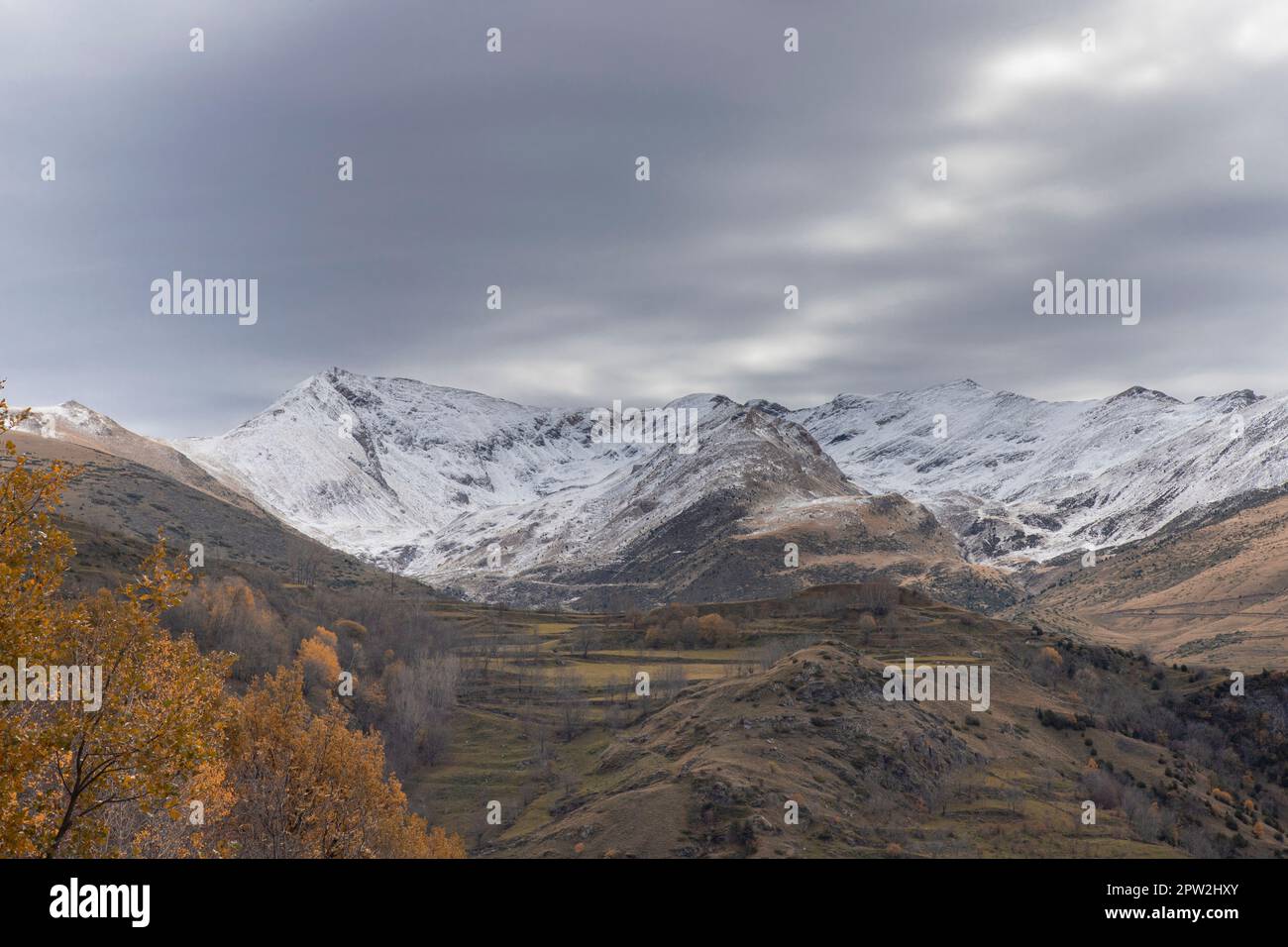 Montagne innevate sotto il cielo nuvoloso paesaggio in Valle Boi nei Pirenei in Catalogna Foto Stock