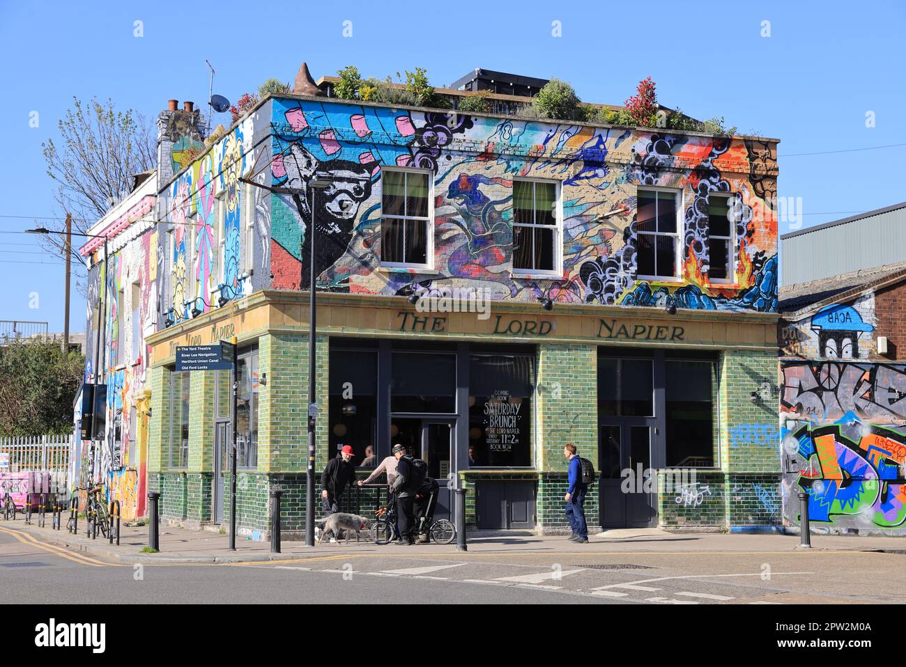 Alla moda Hackney Wick con la sua Street art, sotto il sole di primavera, a est di Londra, Regno Unito Foto Stock