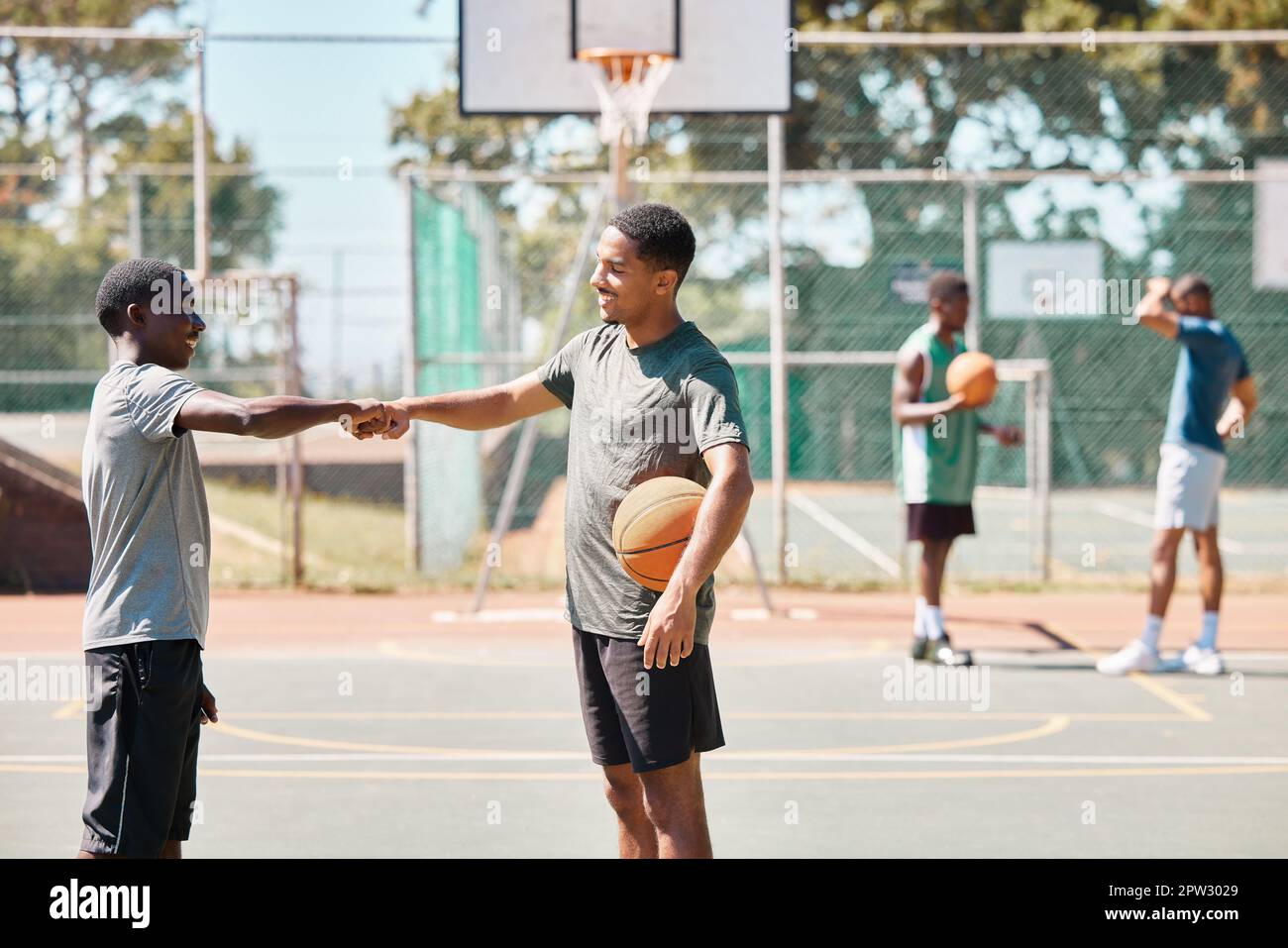 Lavoro di squadra, sport e pugno con l'uomo sul campo da basket per il  fitness, il sostegno e gli amici. Gol, partnership e comunità con il  giocatore di basket Foto stock -