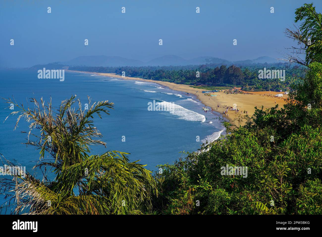 Idilliaca spiaggia di Goa (Karnataka, Kerala) e persone in acqua godendo la vita: Circa 30 gradi di acqua e aria in febbraio su grande distanza. Piccola Foto Stock