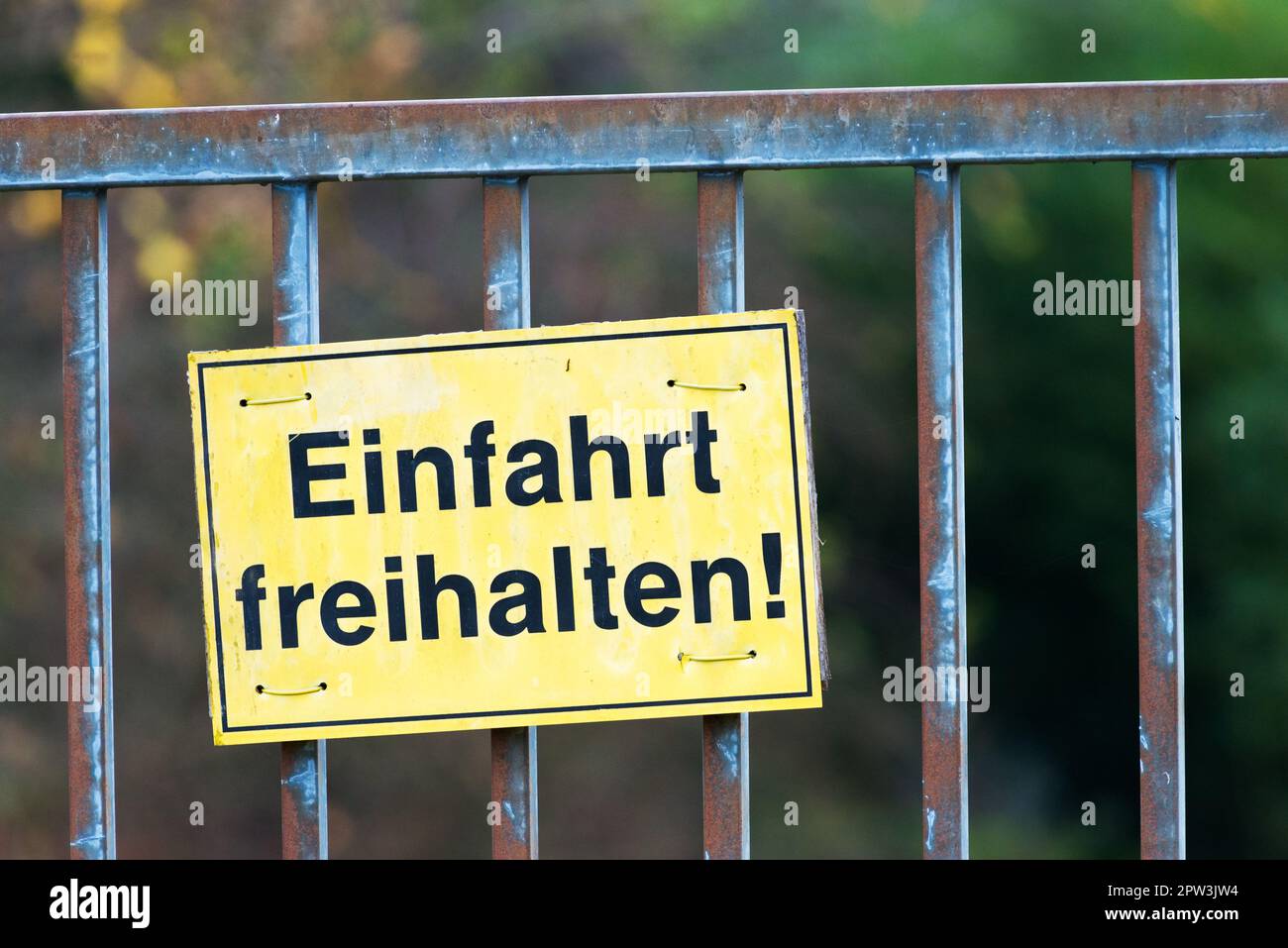 Einfahrt bitte freihalten. (Tenere l'ingresso libero) Vecchio storico cancello di ferro. Cartello bianco con l'iscrizione "tenere l'entrata libera". Lo sfondo è bl Foto Stock