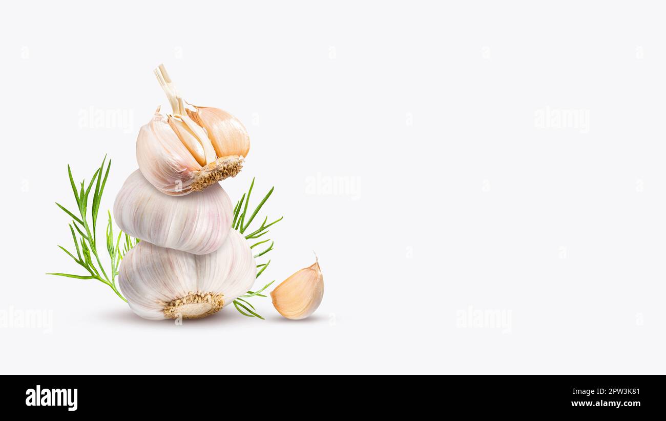 Pila di aglio biologico, spicchi d'aglio e aneto su sfondo grigio chiaro. Torre di verdure piccanti radice. Equilibrio galleggiante cibo equilibrio. Foto Stock