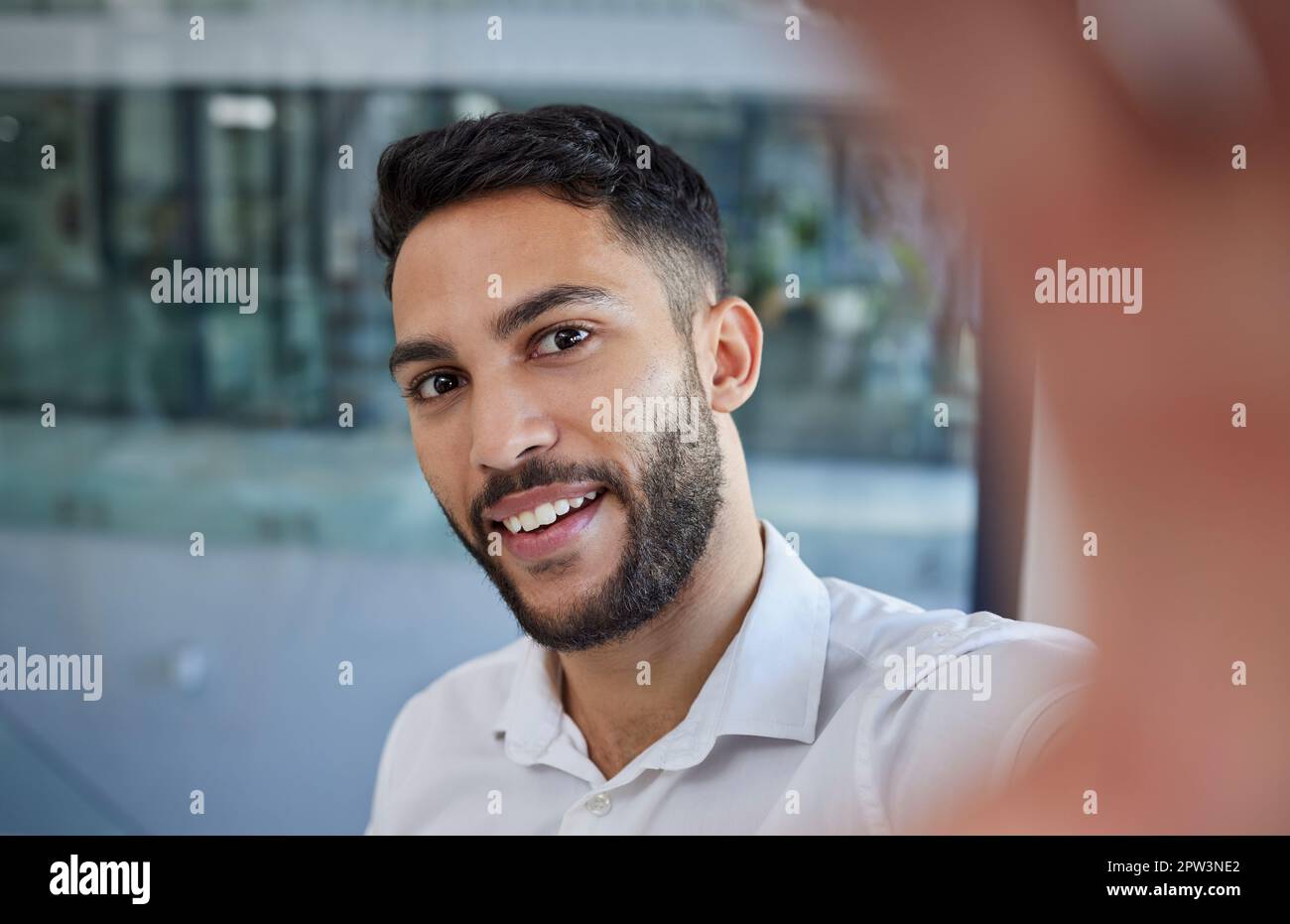 Uomo d'affari, selfie e sorriso per socila media profilo immagine con felicità e orgoglio nella scelta di carriera mentre in ufficio. Faccia del maschio professionale e. Foto Stock