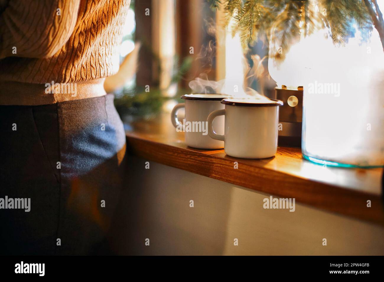 Bevanda calda di Natale - due tazze di VIN brulé con spezie e frutta o tè sul davanzale. Decorazione di Capodanno su sfondo retrò in legno Foto Stock