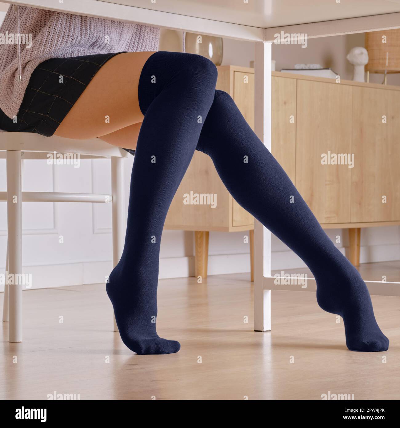 Gambe femminili in calze di ginocchio caldo sotto il tavolo Foto stock -  Alamy