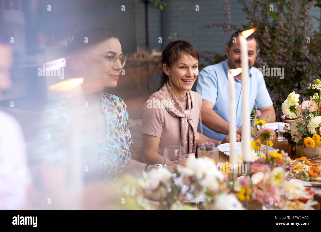 Molta gente che dice i saluti e che mostra i loro calici dello champagne pieni di vino frizzante a vicenda mentre godendo una festa di nozze all'aperto su un Foto Stock