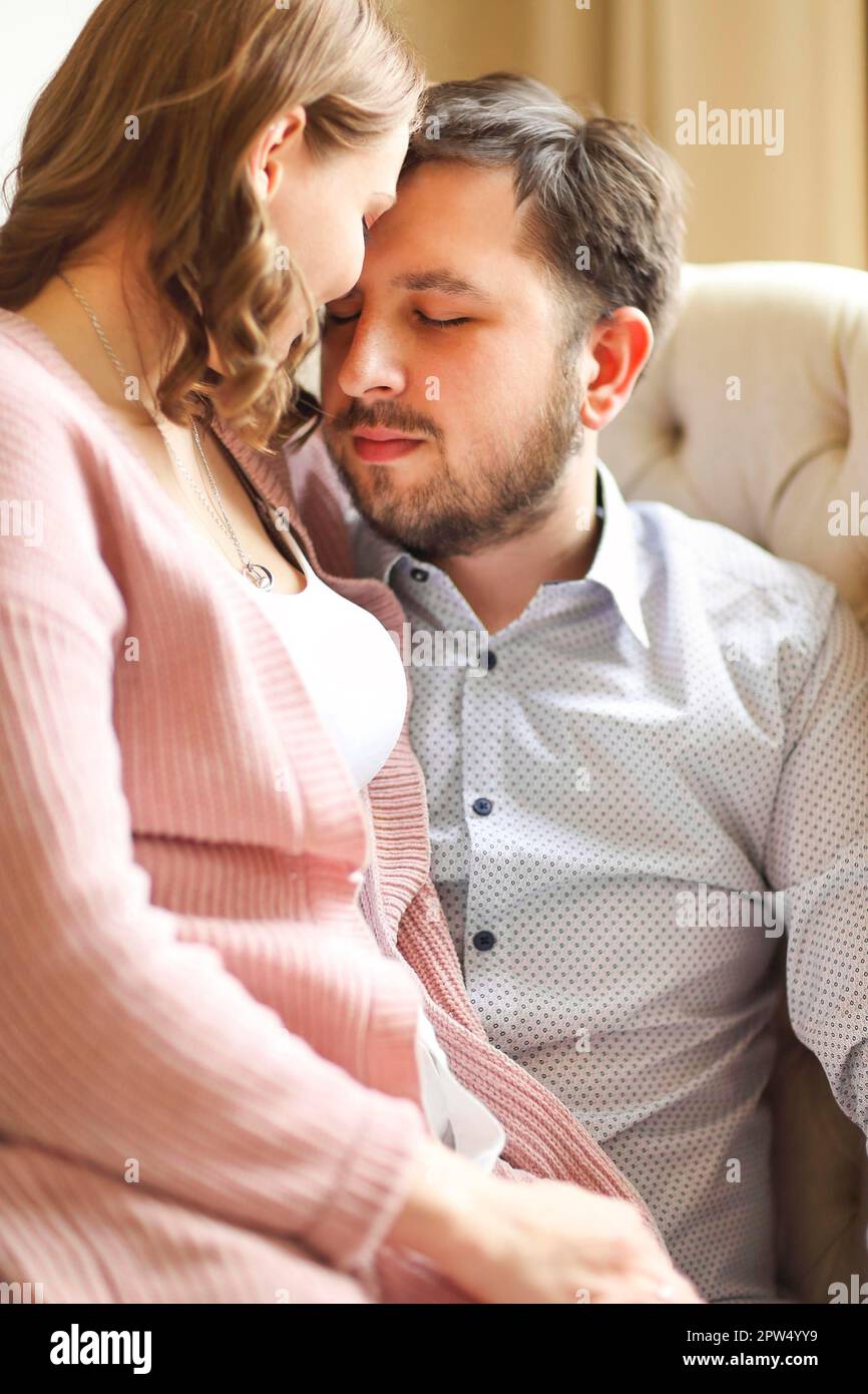 Vista laterale della coppia amorevole del soddisfare abbracciando delicatamente su bianco sfondo a casa Foto Stock