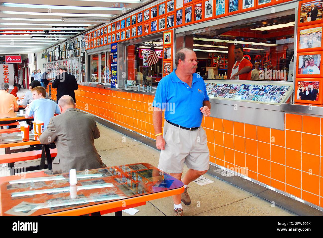 Un uomo adulto si avvicina al bancone per ordinare un Philly Cheesesteak al Genos Steakhouse, South Philadelphia Foto Stock