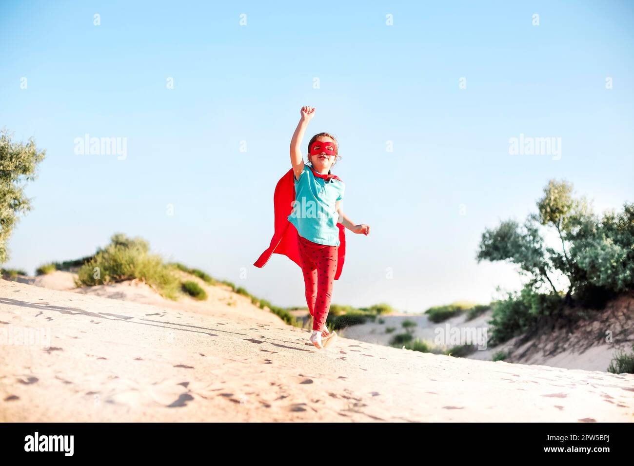 Ritratto di Superhero capretto contro sfondo blu del cielo. Concetto di gioia e infanzia Foto Stock