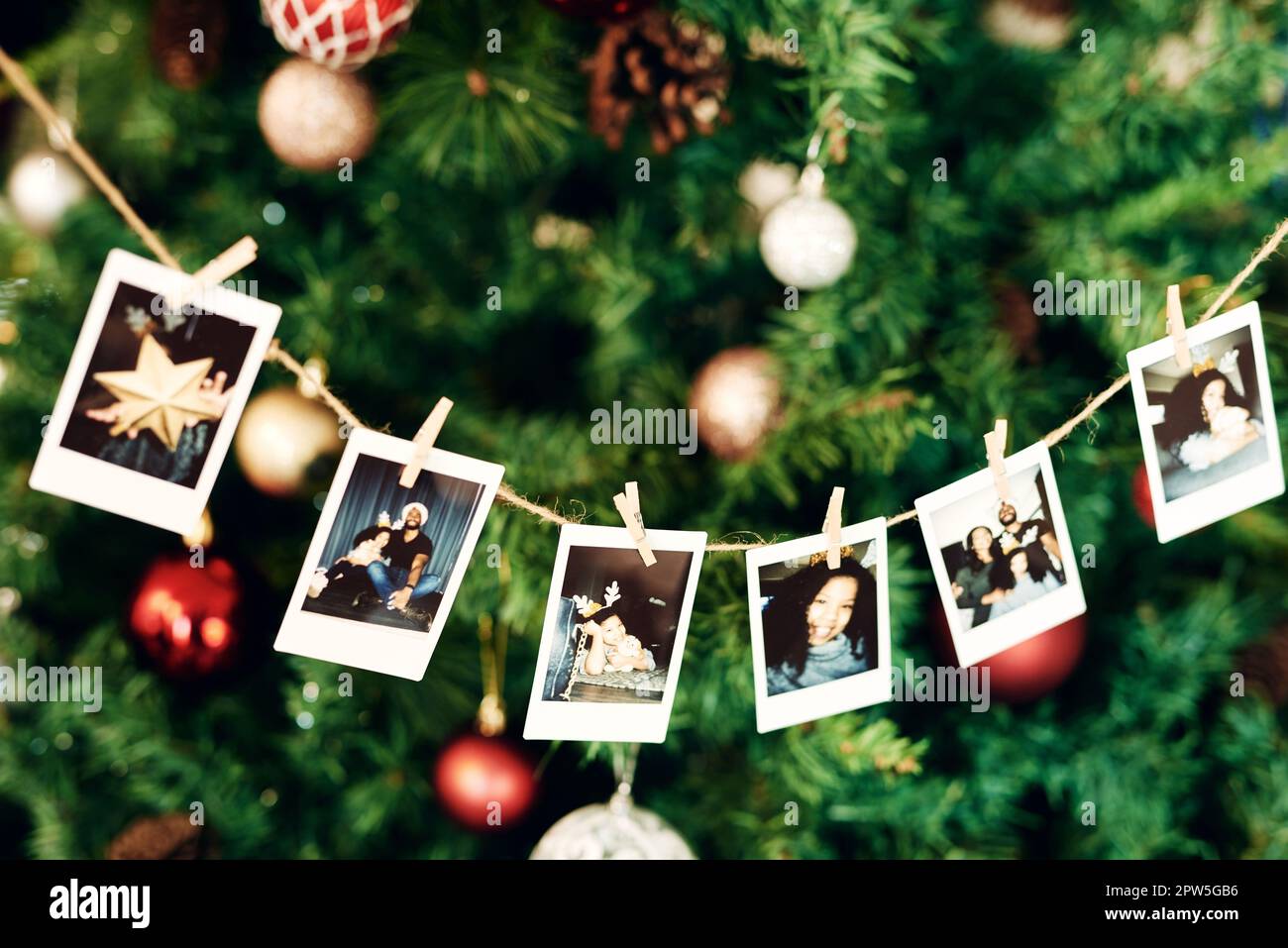 Natale, fotografia e ricordi con una fila di immagini appese su un albero  di Natale per la celebrazione o la tradizione. Famiglia, casa e allegro con  decora Foto stock - Alamy