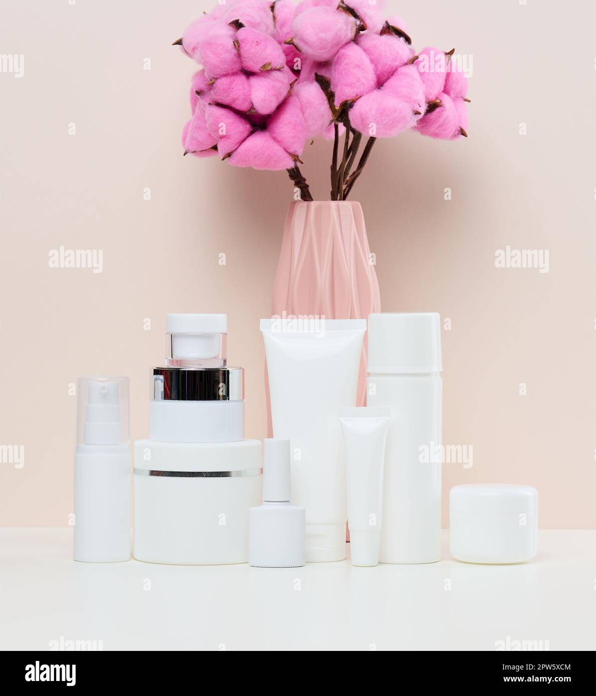 Vasetti e tubi in plastica bianca per cosmetici liquidi su fondo bianco. Branding, pubblicità Foto Stock