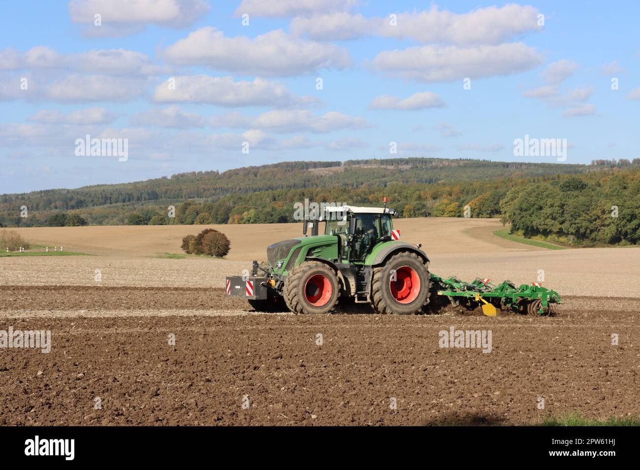 Landwirt eggt mit seinem Traktor ein Feld nahe der Sababurg, Hessen, Deutschland, Hofgeismar Foto Stock