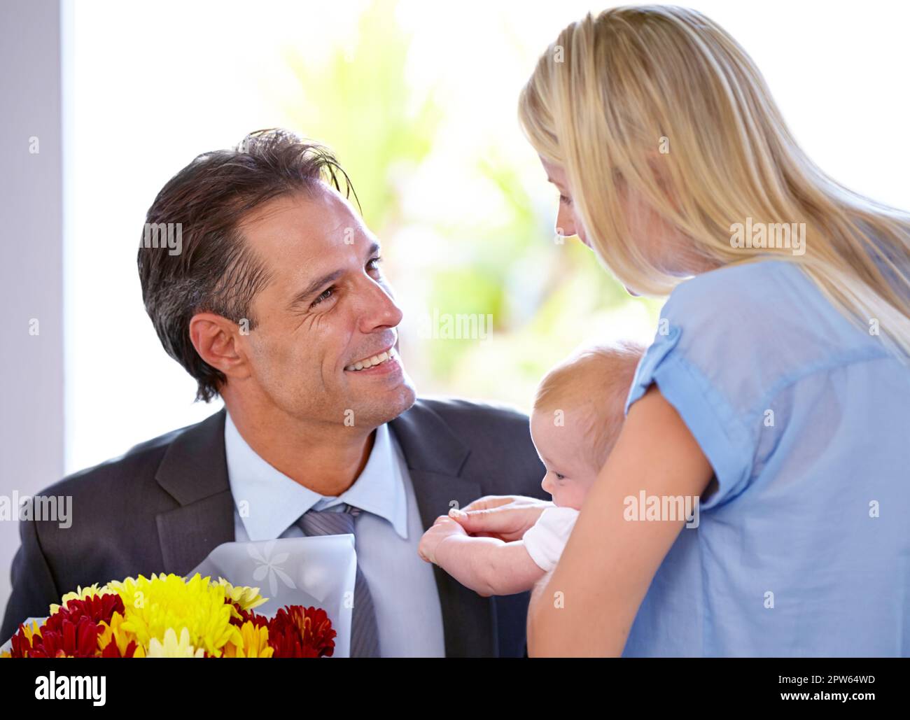Ho dei fiori per te il mio amore. Bel padre sorridendo alla sua bella  famiglia Foto stock - Alamy