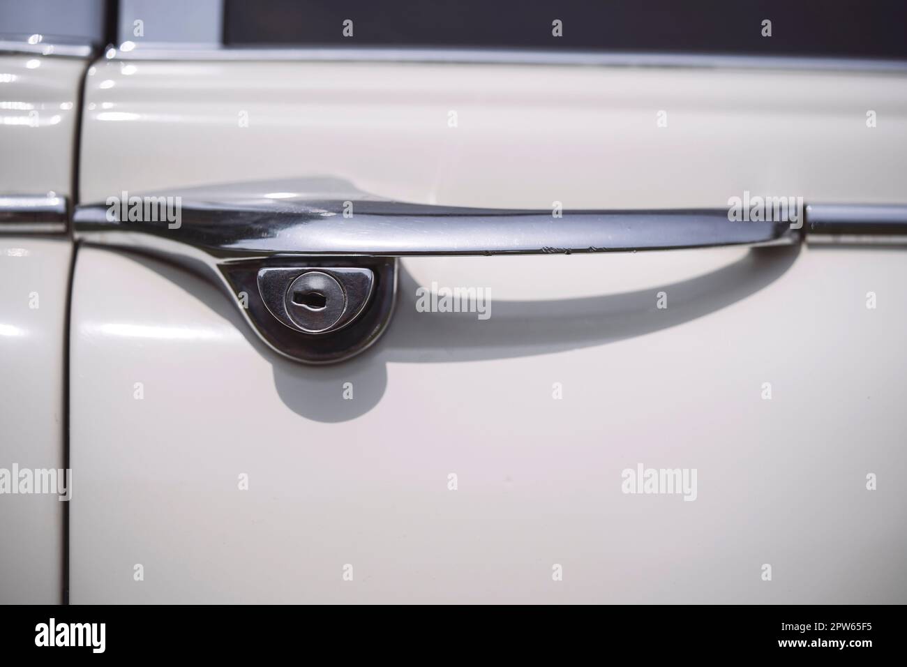Primo piano di una maniglia vintage della portiera di un'auto bianca. Foto Stock
