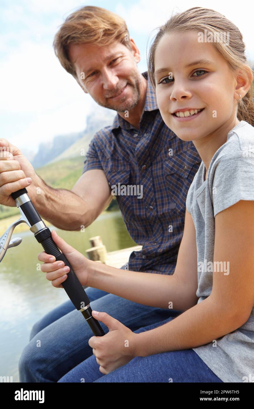 Prendo pesce più grande di mio padre. Ritratto di un padre e di una figlia seduti e di pesca Foto Stock