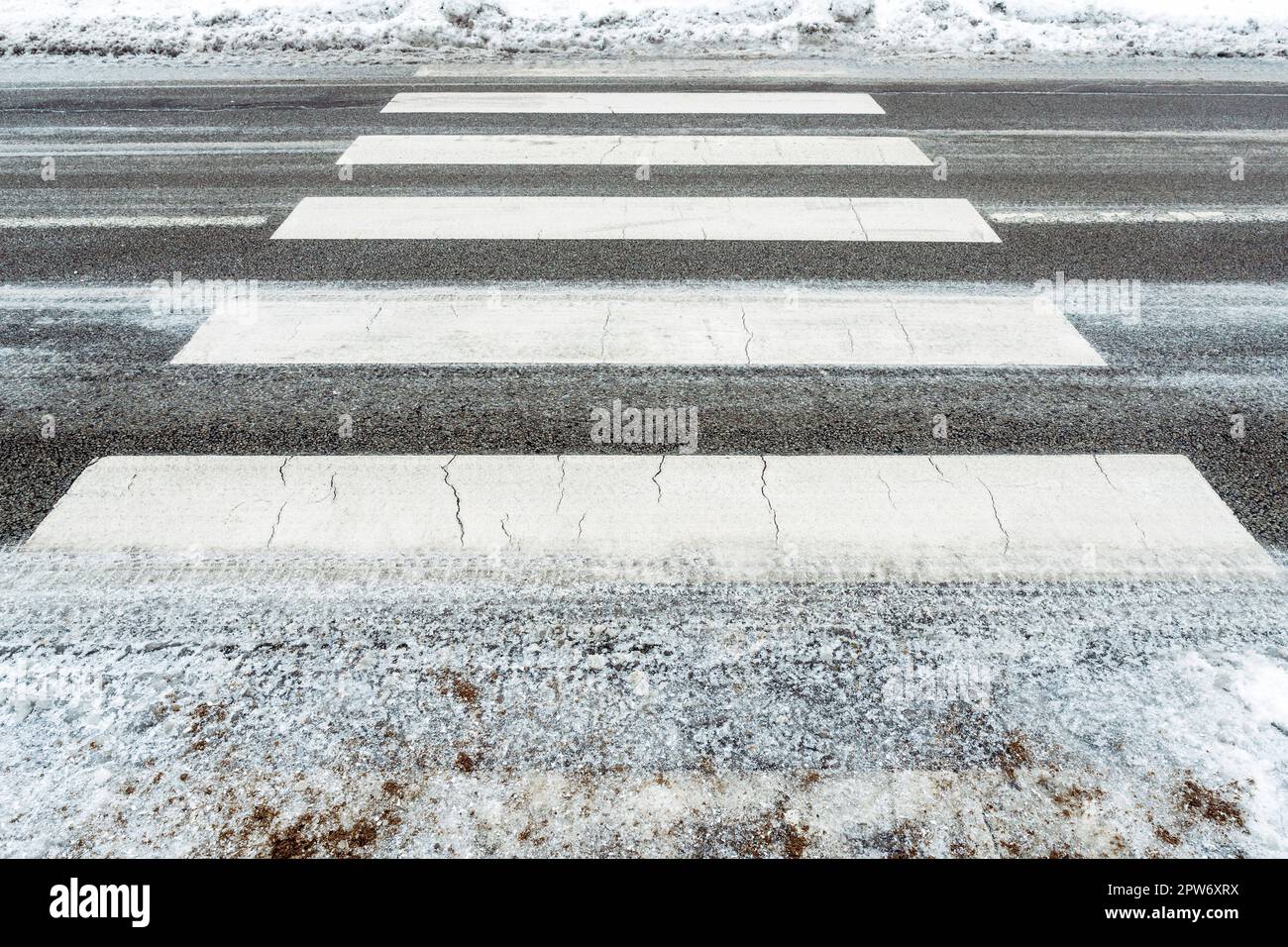 Neve, ghiaccio e fango invernale in un passaggio pedonale. La temperatura dell'aria è di circa -10. Condizioni di guida difficili. Distanza di frenata della vettura. Tram Foto Stock