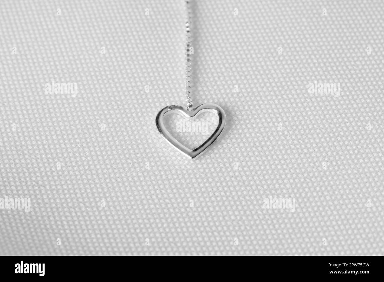 Elegante collana in argento con dettagli a forma di cuore. Sfondo bianco. Foto Stock