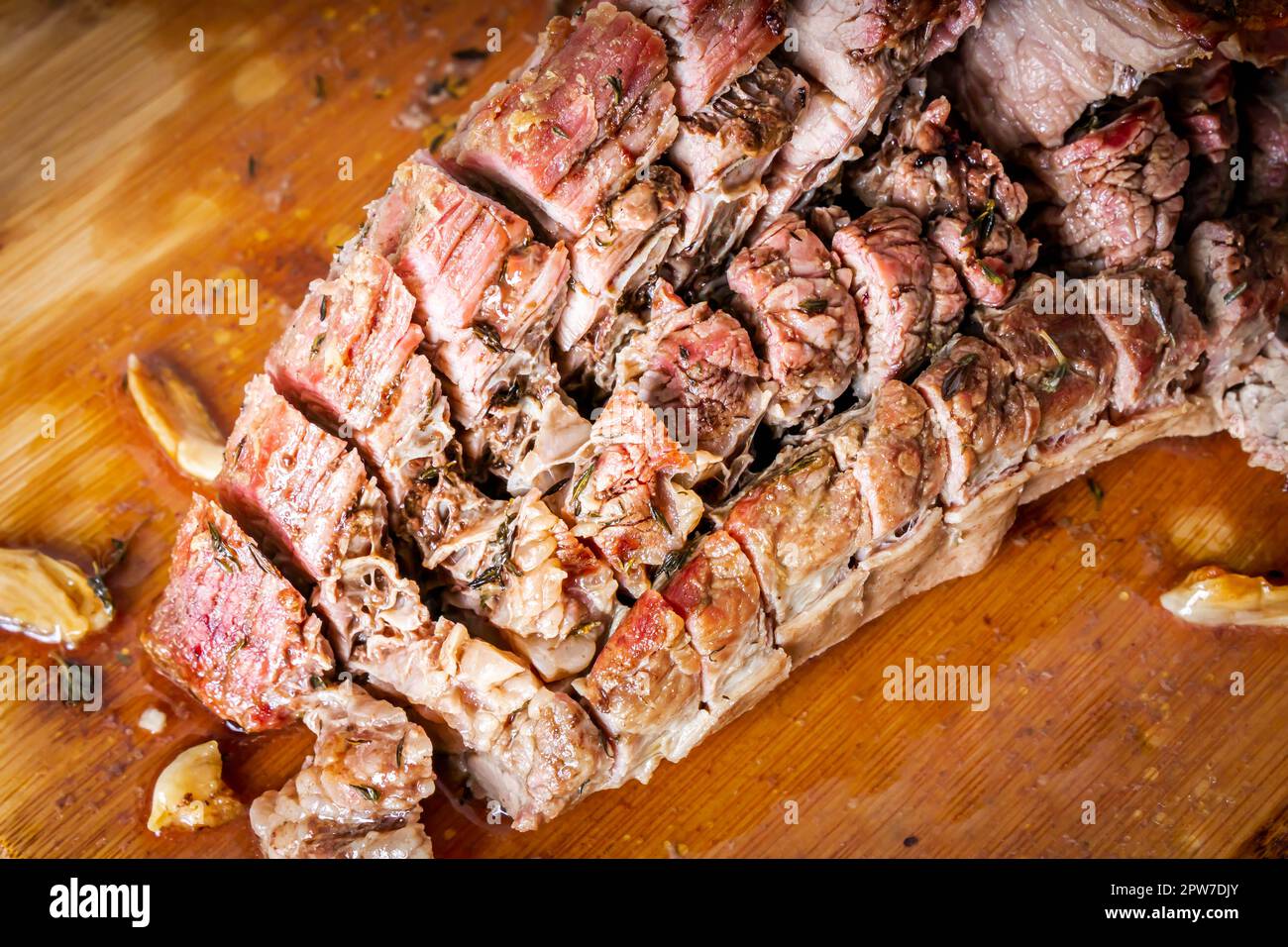 FLANK STEAK Beef BBQ food. Carne arrosto con patate e timo su un asse di legno, completamente tagliata a fette. Foto Stock