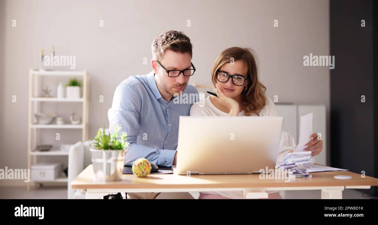 Famiglia felice che usa il calcolatore per le tasse e il preventivo Foto Stock