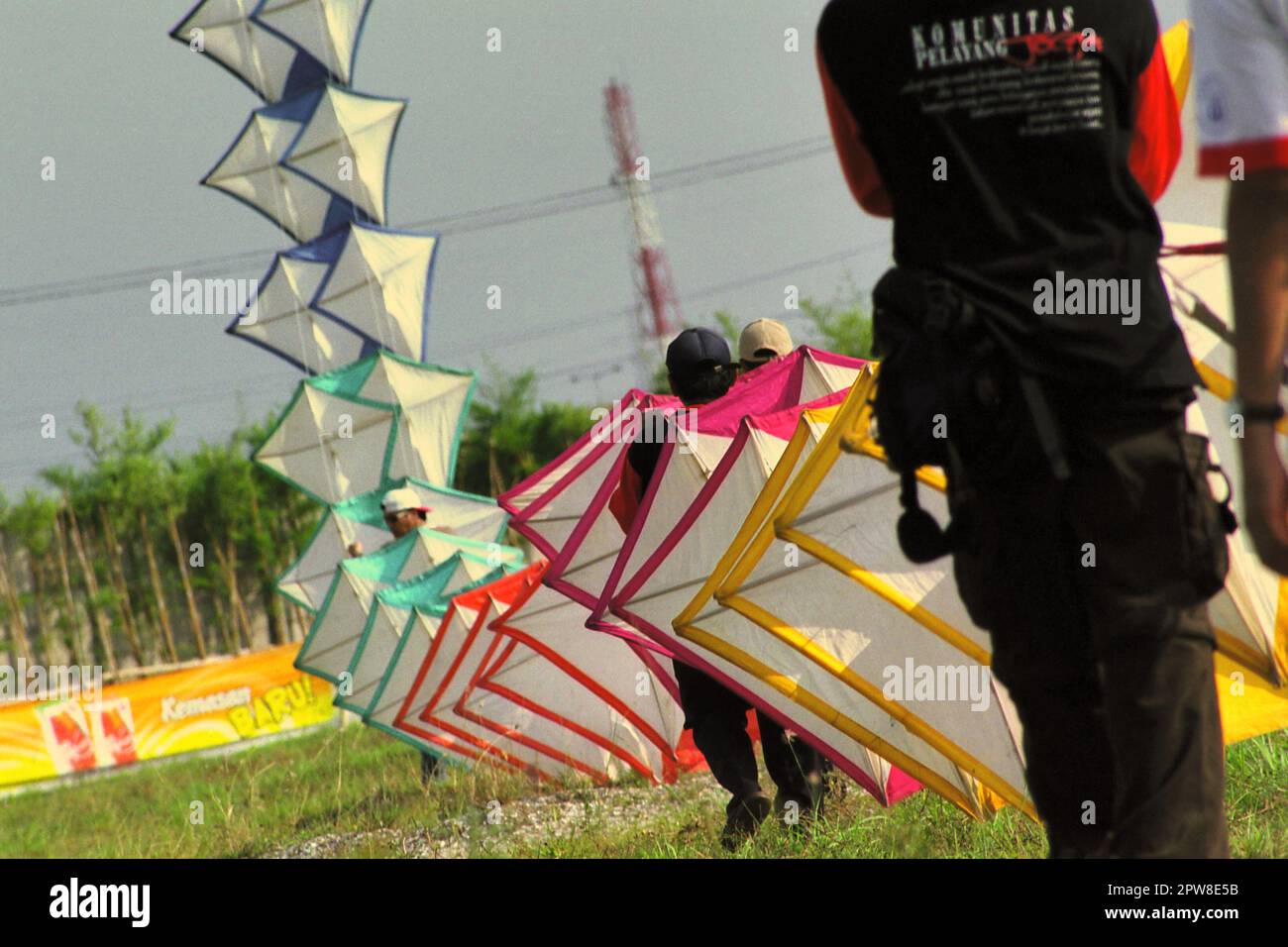 Uomini che volano un aquilone gigante durante il 2004° Festival Internazionale di Kite di Giacarta che si è tenuto il 9-11 luglio a Karnaval (Carnival) Beach ad Ancol Dreamland, nella zona nord di Giacarta, Jakarta, Indonesia. Foto Stock