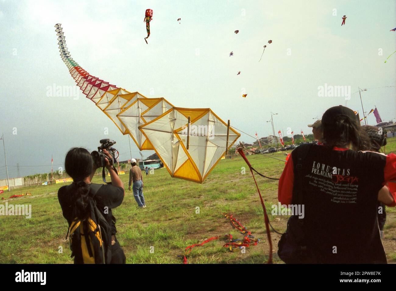 Uomini che volano un aquilone gigante durante il 2004° Festival Internazionale di Kite di Giacarta che si è tenuto il 9-11 luglio a Karnaval (Carnival) Beach ad Ancol Dreamland, nella zona nord di Giacarta, Jakarta, Indonesia. Foto Stock