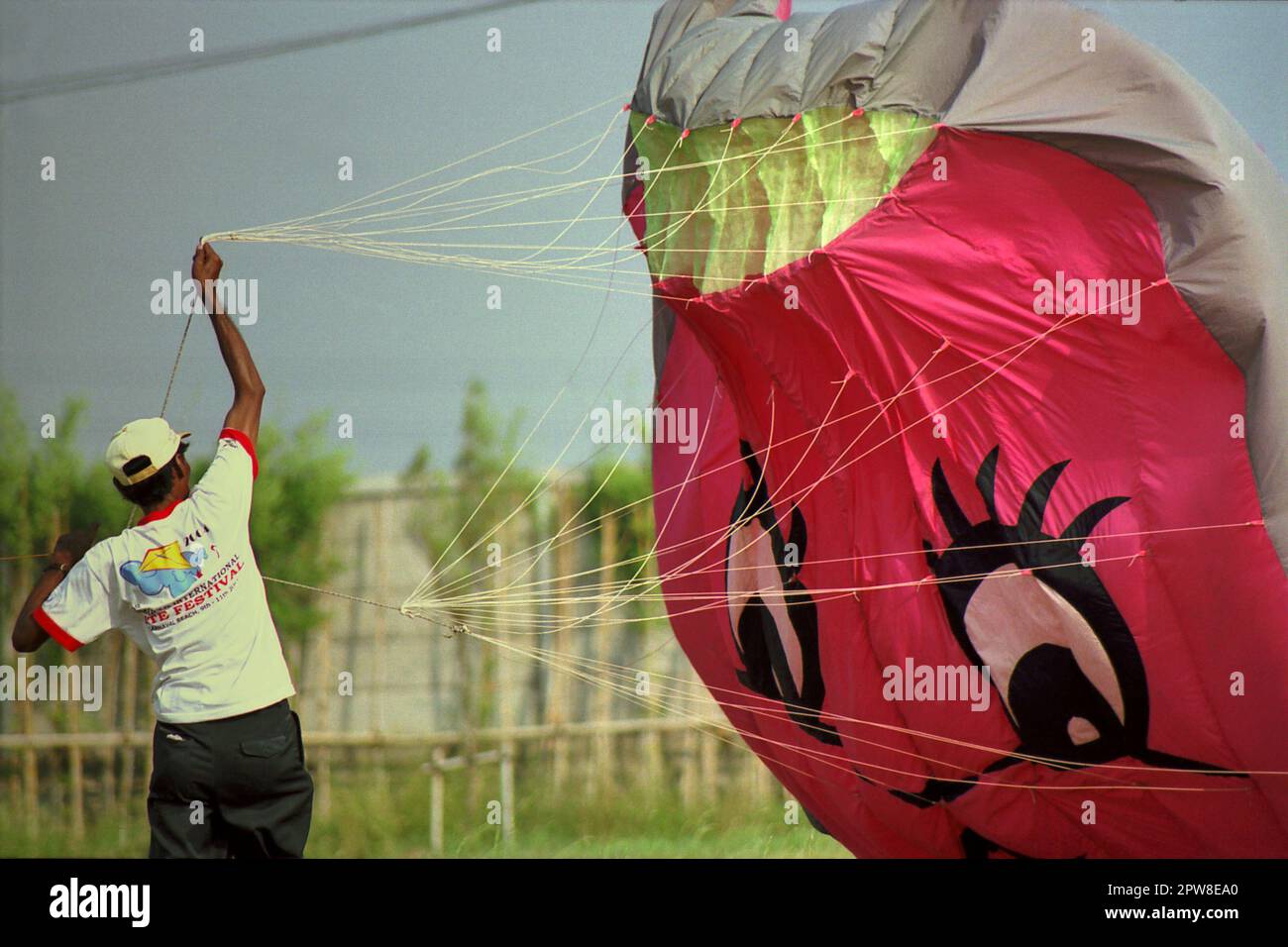 Un partecipante sta volando un aquilone in mongolfiera durante il 2004° Jakarta International Kite Festival che si è tenuto il 9-11 luglio a Karnaval (Carnival) Beach ad Ancol Dreamland, nella zona nord di Giacarta, Indonesia. Foto Stock
