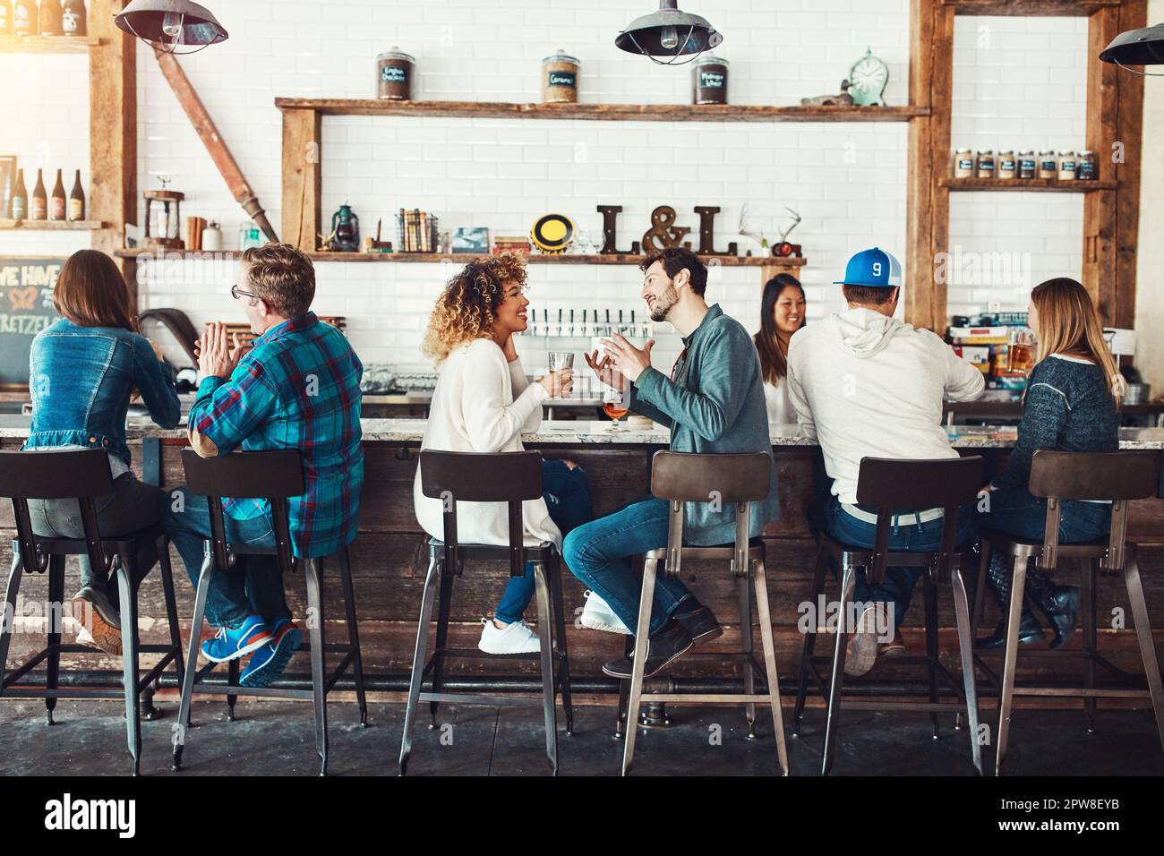 Sempre desiderosi di festeggiare il fine settimana. i giovani si gustano un drink in un bar. Foto Stock