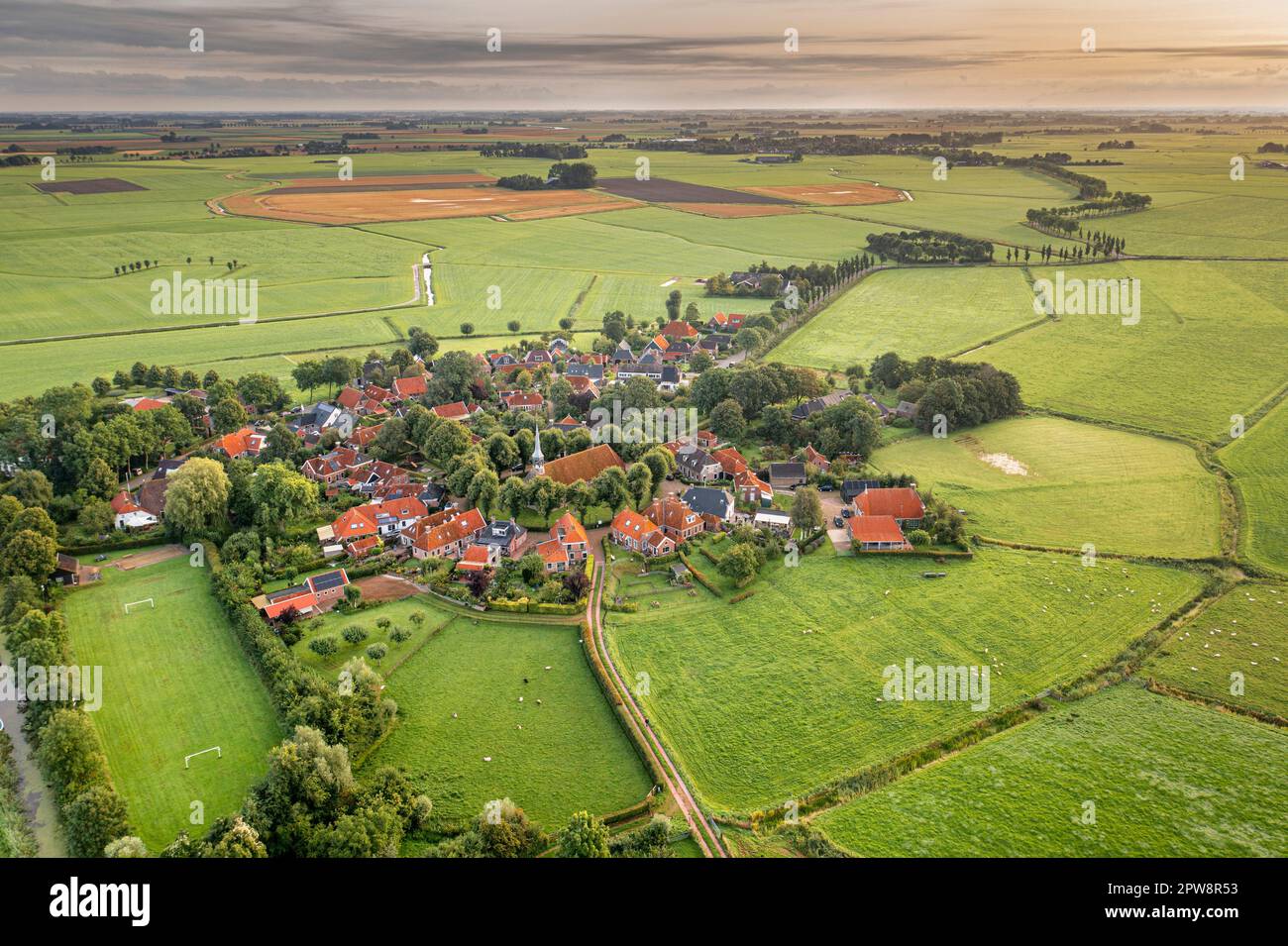 I Paesi Bassi, il villaggio di tumuli radiali di Niehove. Una chiesa medievale si trova nel centro del paese. Vista aerea. Foto Stock
