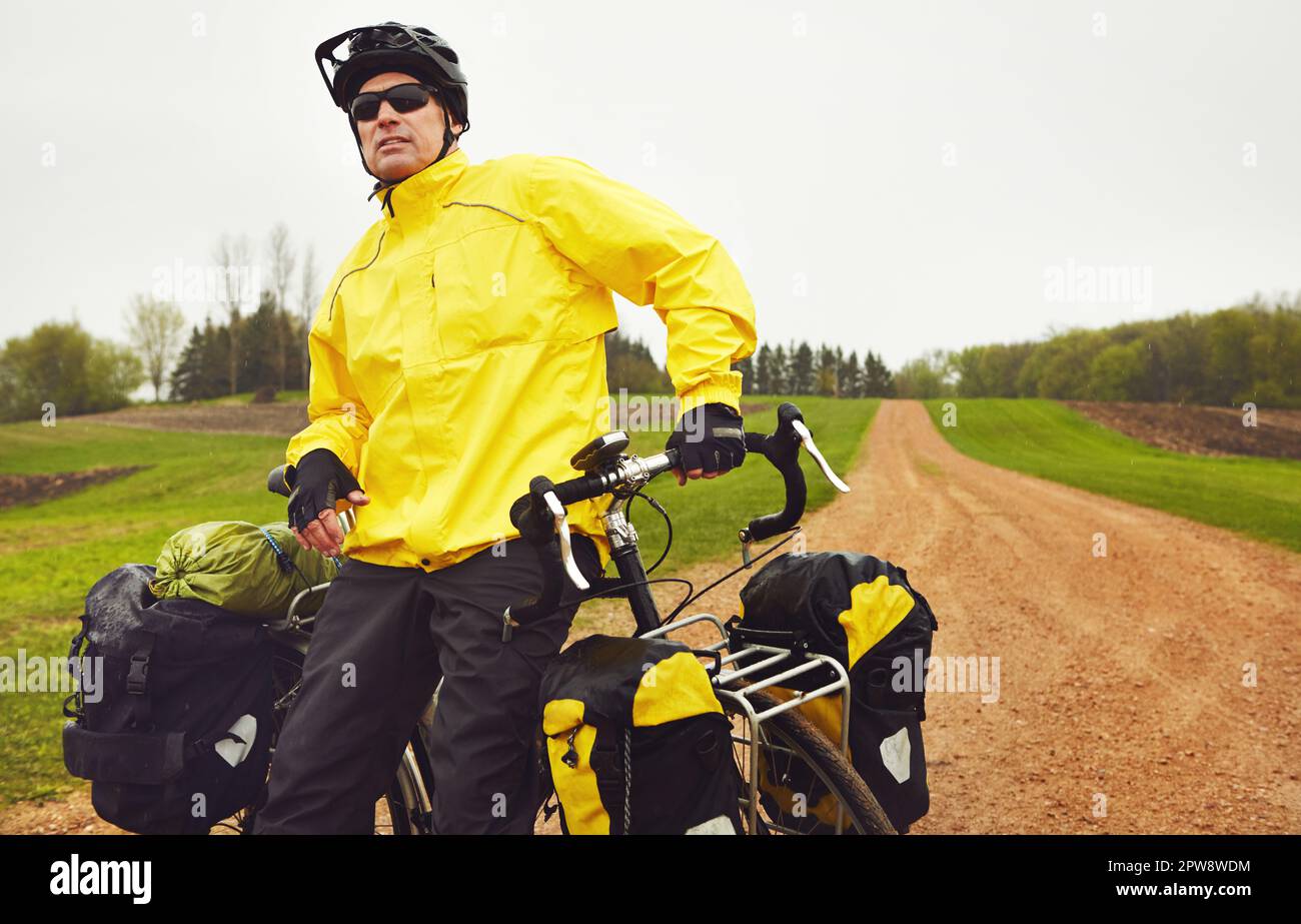 Non lasciate che il tempo vi fermi dal andare in bicicletta. un ciclista maschio che si diverte in bicicletta su un inverno bagnato mattina. Foto Stock