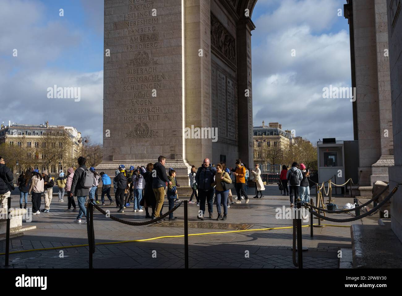 Turisti e scolaresche sotto l'Arco di Trionfo in primavera mattina a Parigi, Francia. Marzo 25, 2023. Foto Stock
