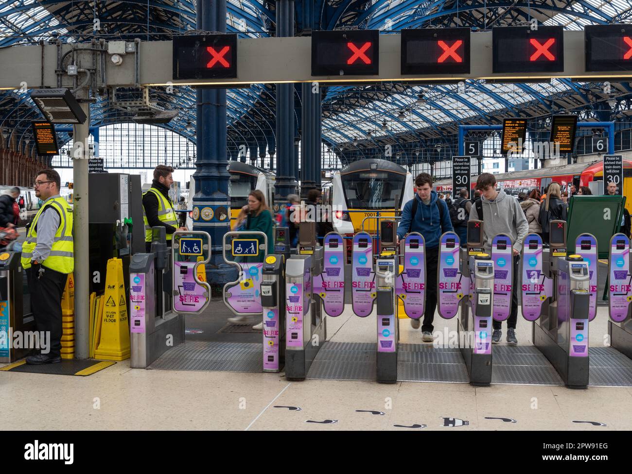 Passeggeri e pendolari che attraversano cancelli elettronici presso la stazione di Brighton in Inghilterra. Aprile 2023 Foto Stock