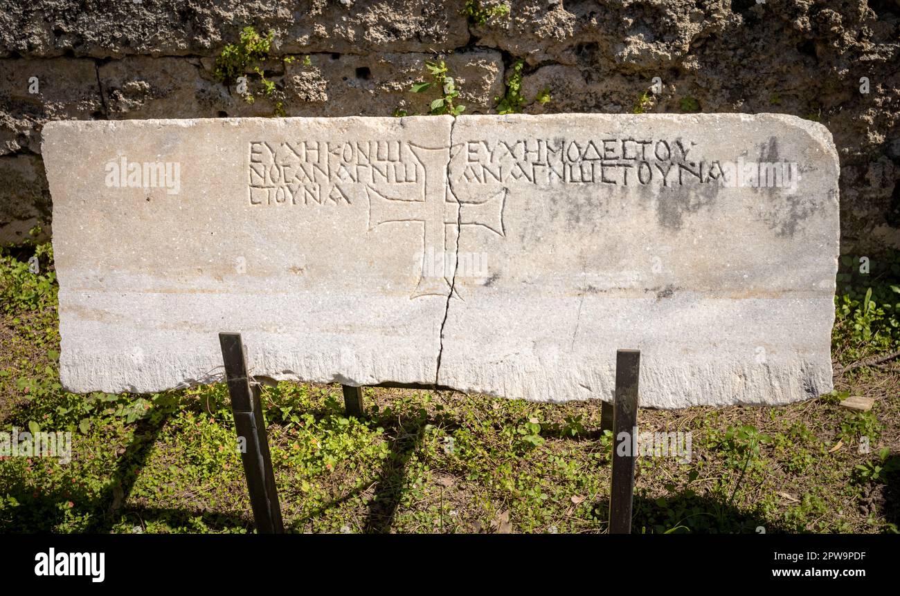 Una pietra di epoca romana incisa che mostra anche una croce cristiana nel cortile del museo laterale a Side, provincia di Antalya, Turchia (Turkiye). Il museo i Foto Stock