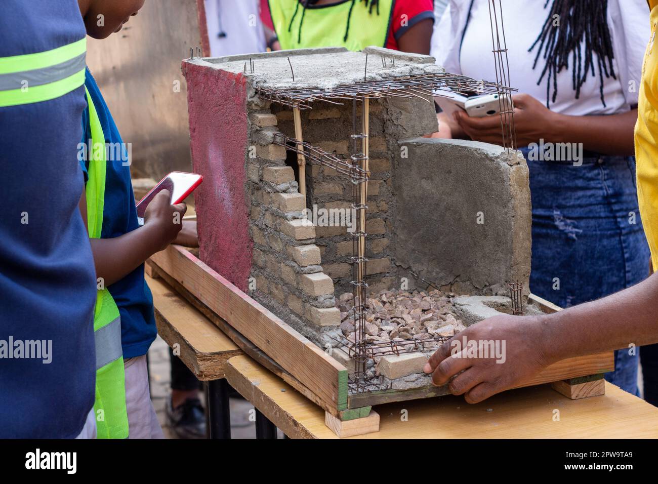 Giovani ingegneri che costruono una casa in miniatura in Africa Foto Stock