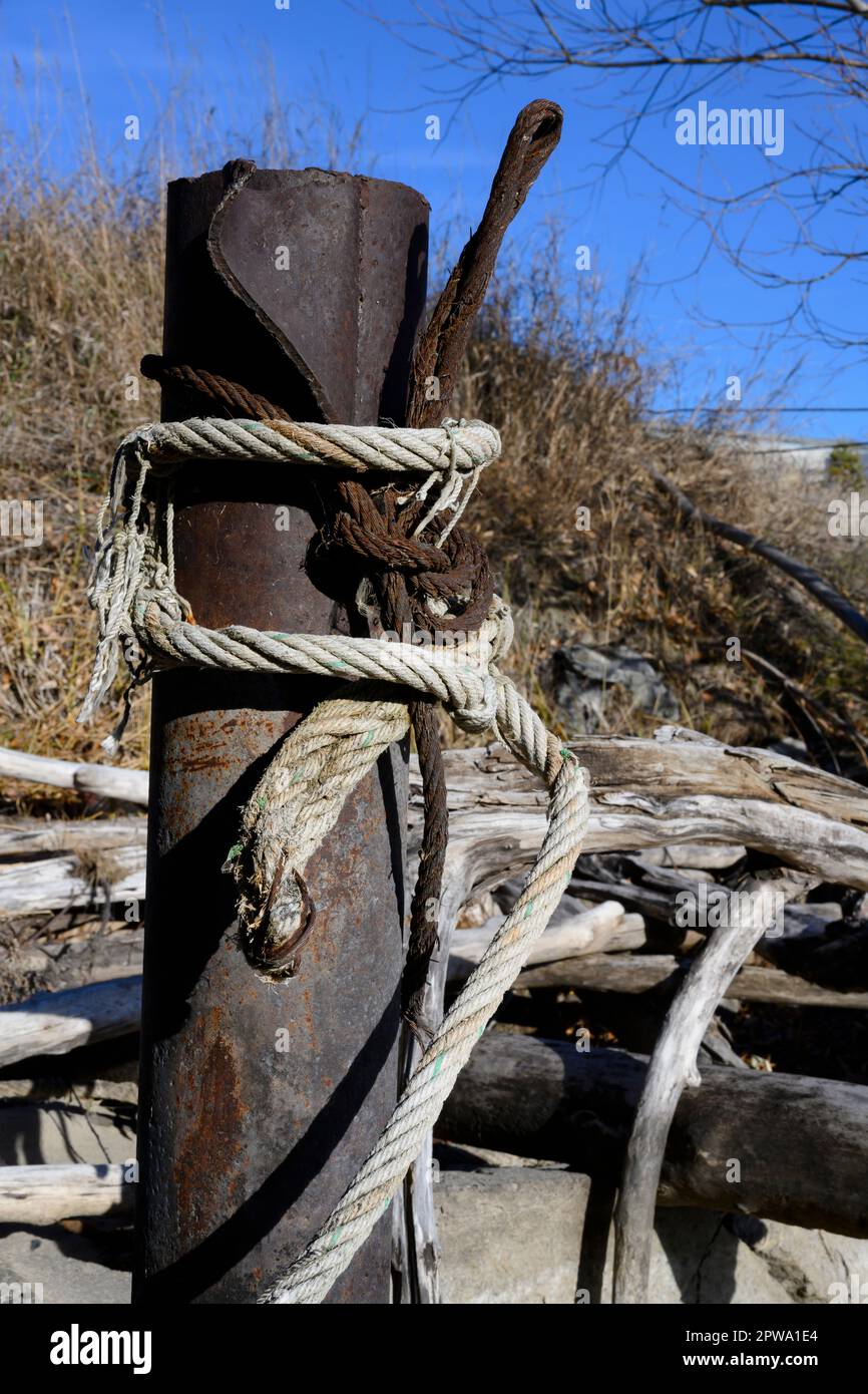 Un palo arrugginito a cui le barche da pesca sono legate con cavi e corde Foto Stock
