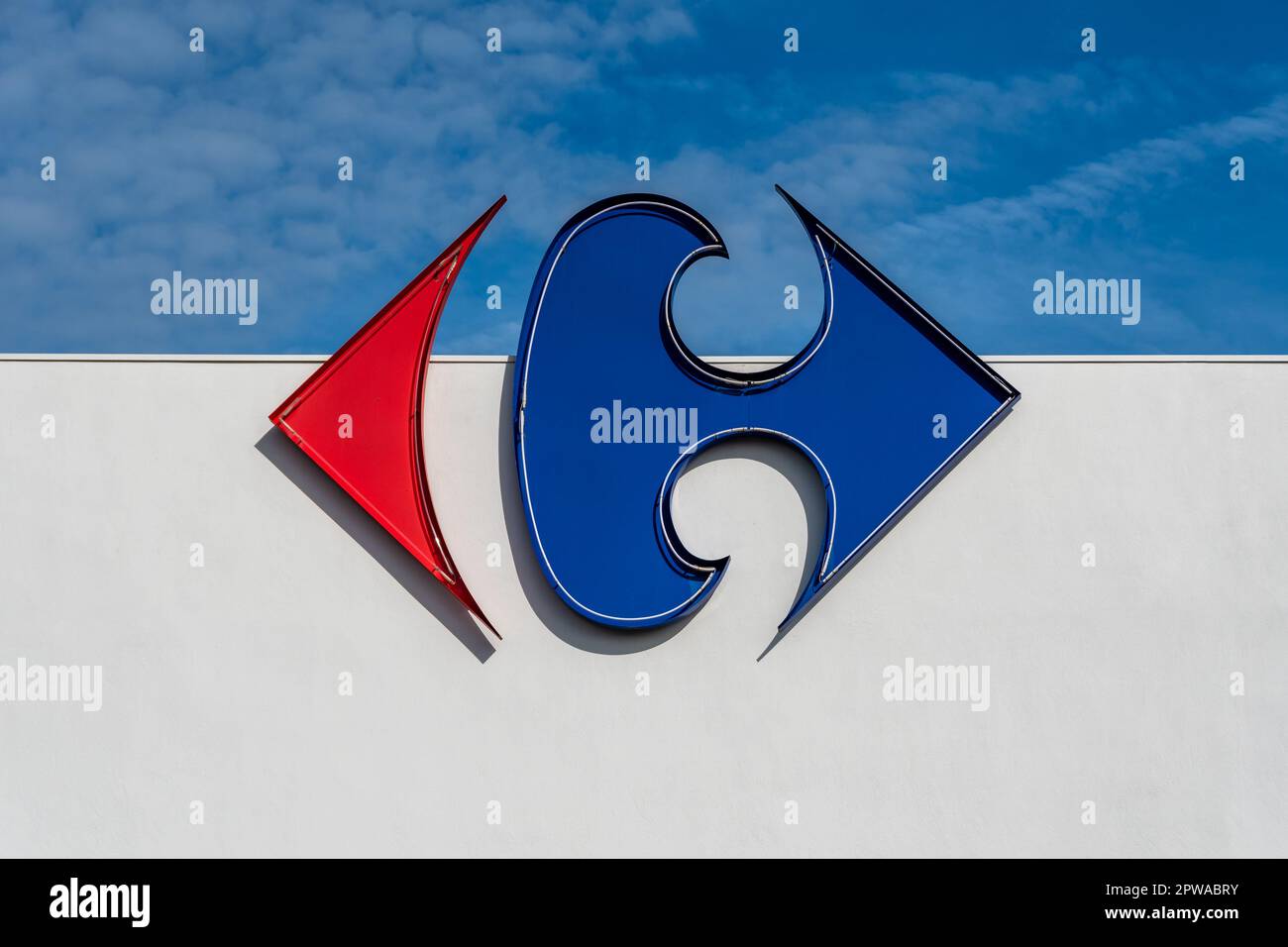 Anglet, Francia - 26 aprile 2023: Logo del gruppo Carrefour su una parete bianca e sfondo cielo blu Foto Stock
