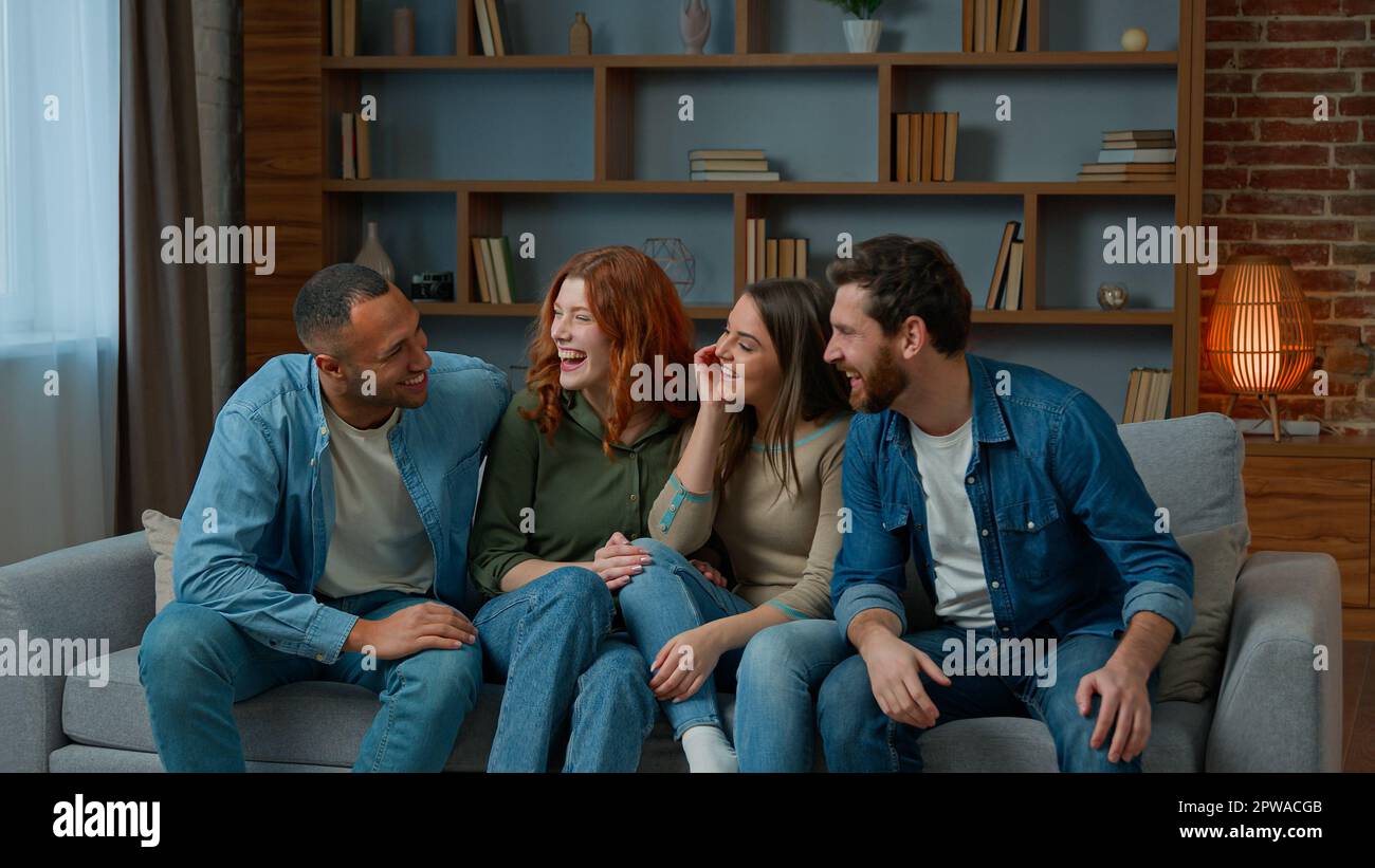 Gruppo di etnicità diverse afroamericano ispanico caucasico persone migliori amici sedersi vicinanza su comodo divano casa sorridente interno Foto Stock