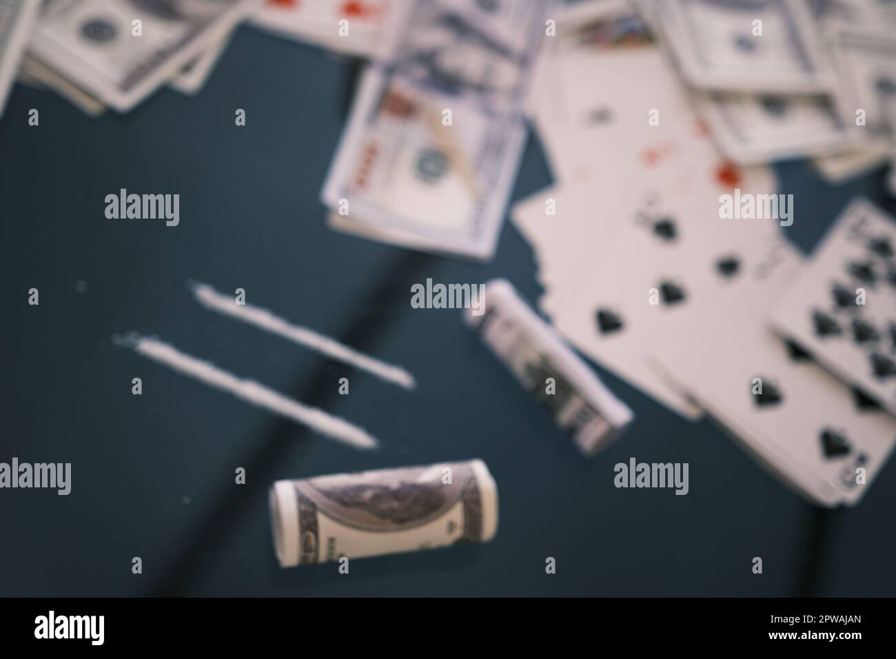 Blured ha rotolato 100 dollari USA, 2 linee di cocaina, droghe illegali su un tavolo di vetro nero. Tossicodipendenza. Con messa a fuoco selettiva. Foto Stock