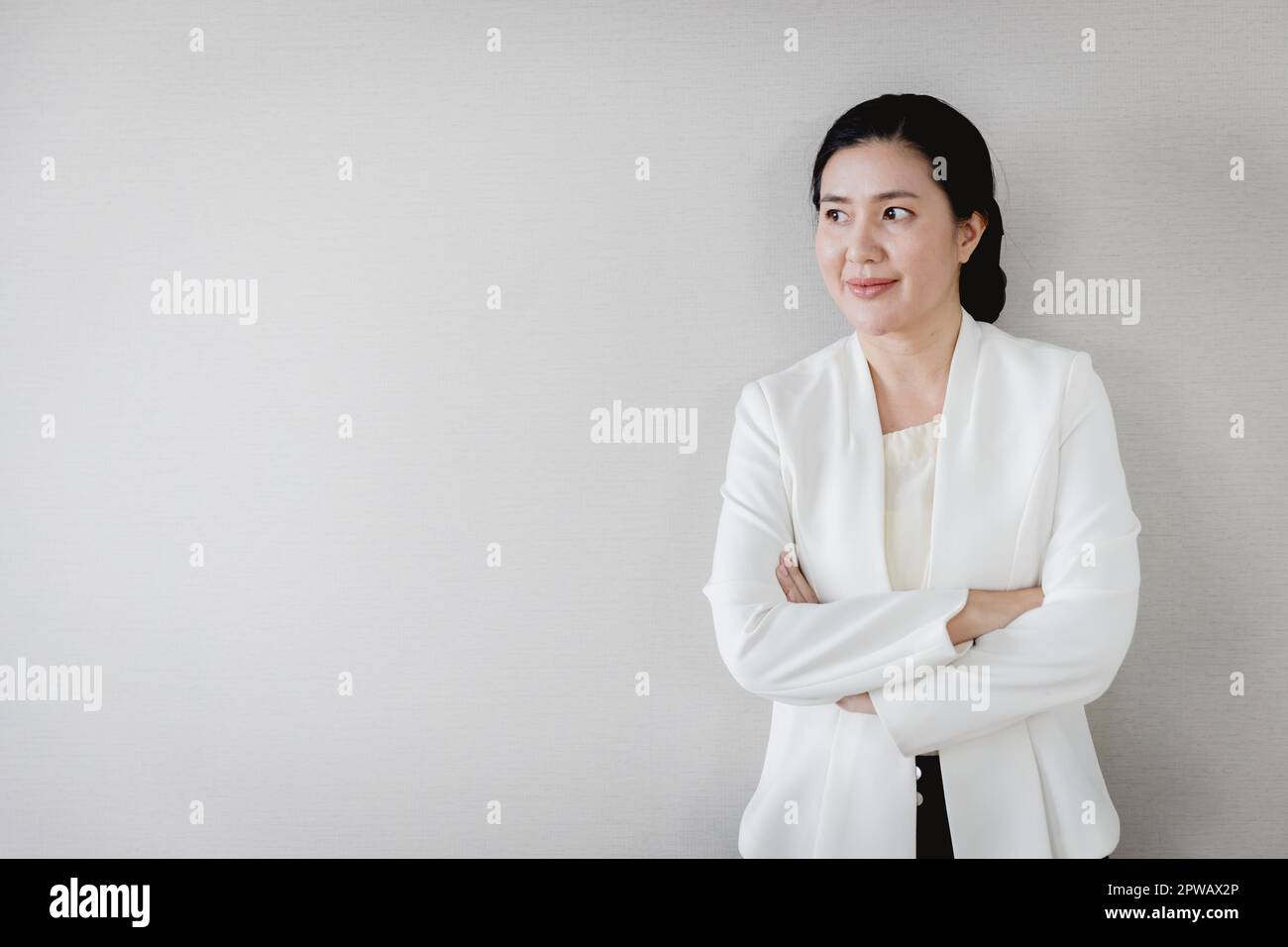 Senior adulto Asian businesswoman leader dirigente titolare di società in piedi fiducioso cercando la visione con lo spazio copia Foto Stock