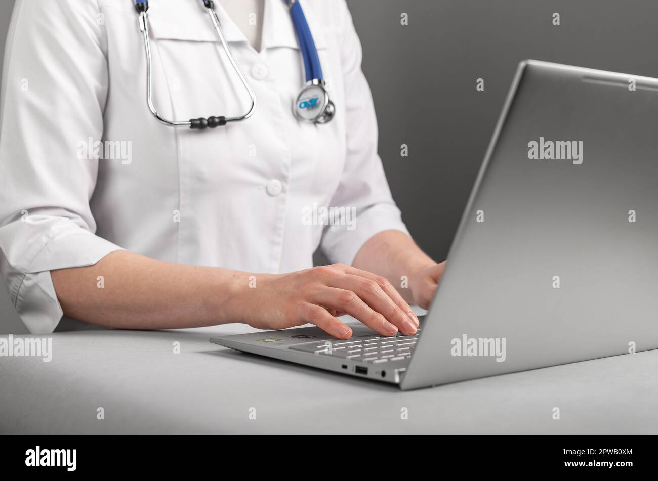 Medico che lavora al computer portatile, utilizzando le tecnologie dell'informazione e l'intelligenza artificiale. Foto Stock