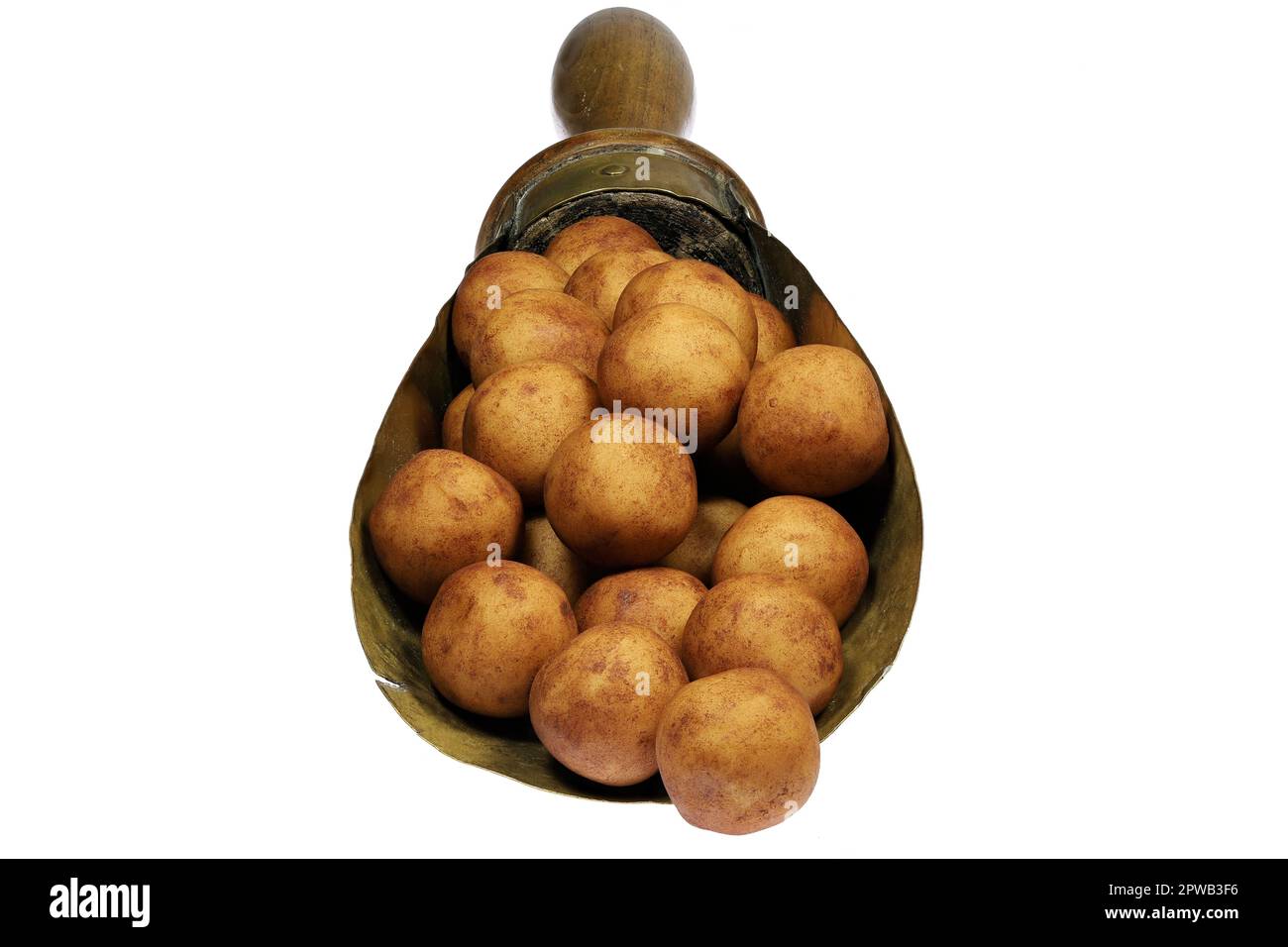 Patate marzapane di Lubecca, Germania, in un misurino di ottone d'annata isolato su fondo bianco Foto Stock