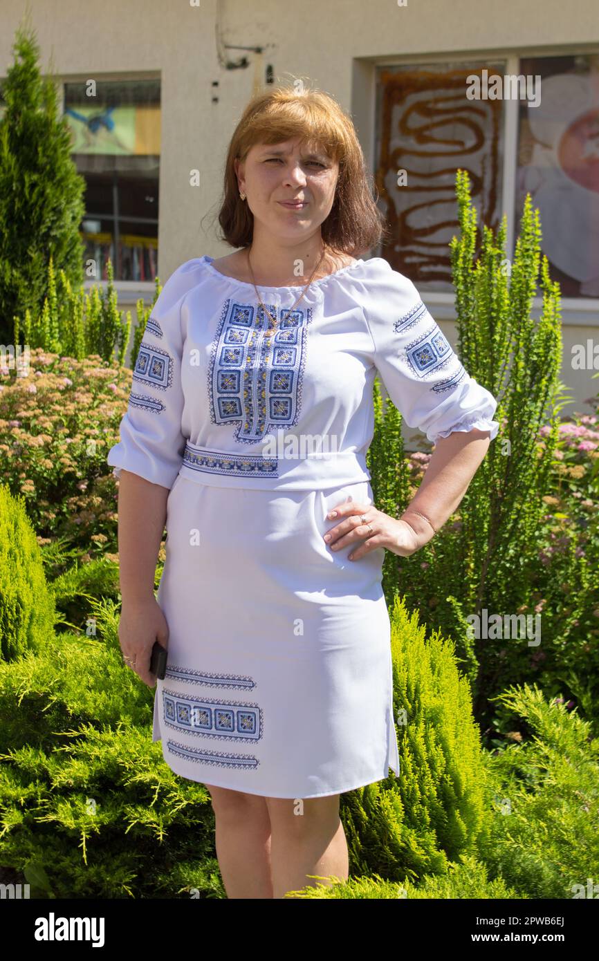 Donna Ucraina ricamata con fili blu sullo sfondo di abete verde Foto Stock