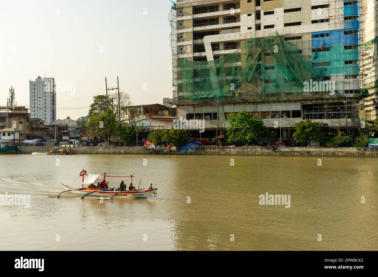 Una piccola barca che naviga lungo il fiume Pasig, Manila, Filippine Foto Stock