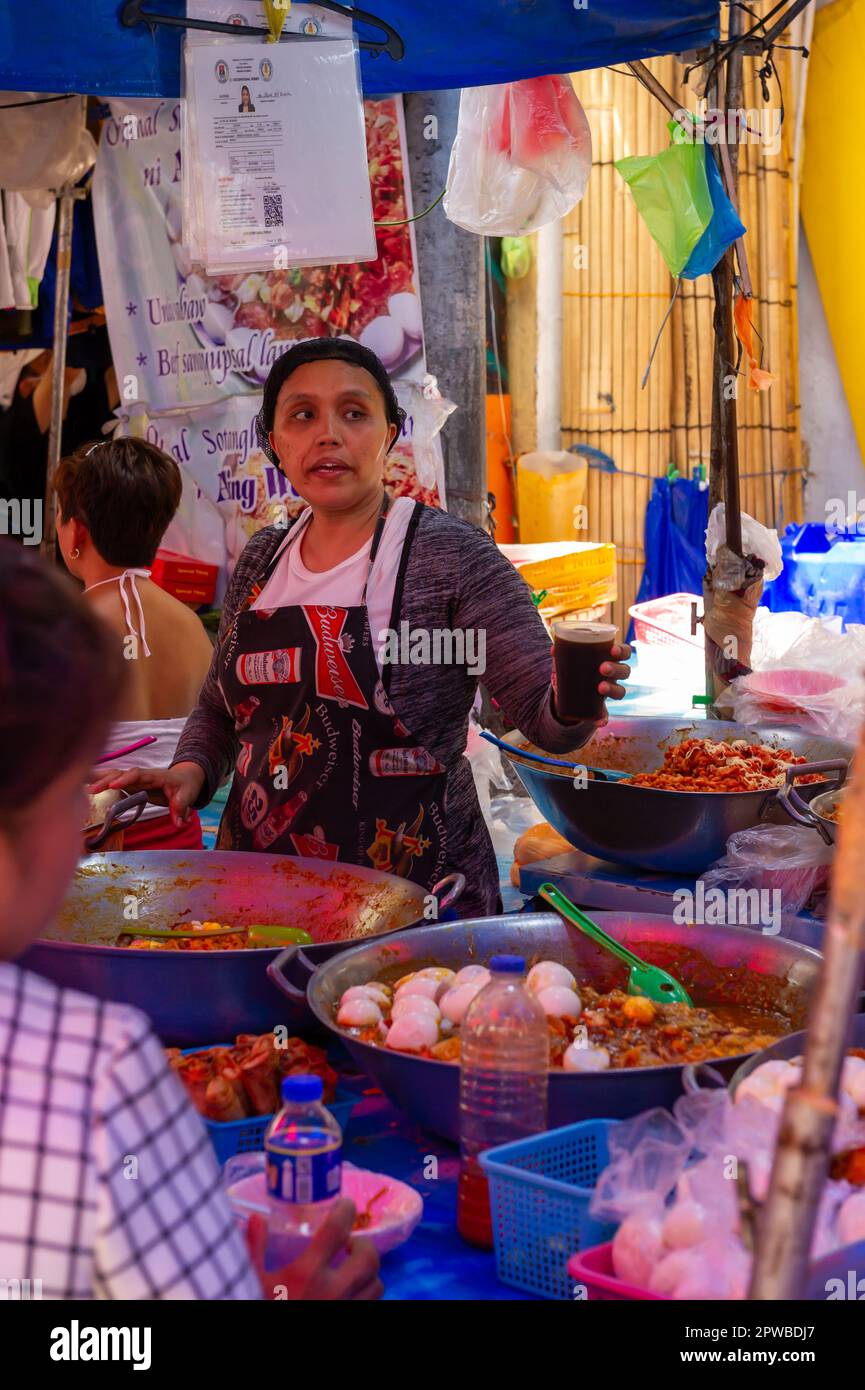 Mangiare cibo di strada filippino al mercato di Quiapo, Manila, Filippine Foto Stock