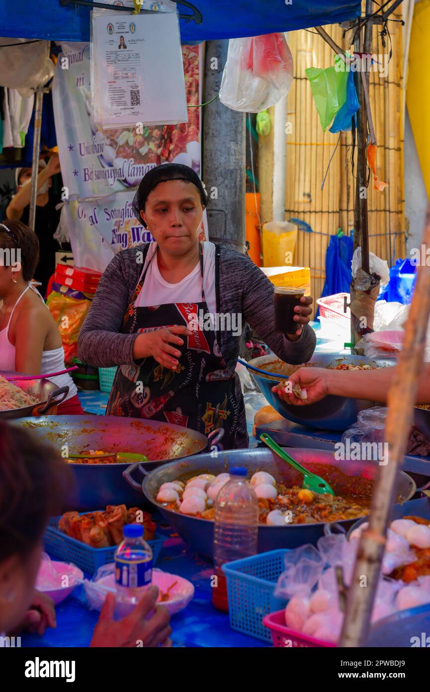 Mangiare cibo di strada filippino al mercato di Quiapo, Manila, Filippine Foto Stock