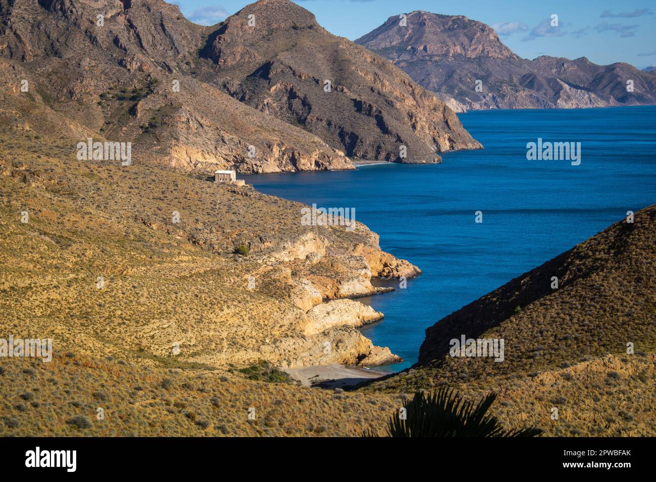 Vista della costa frastagliata di Cartagena, Spagna, con le montagne che raggiungono il mare e le insenature selvagge sullo sfondo in piena luce del giorno Foto Stock