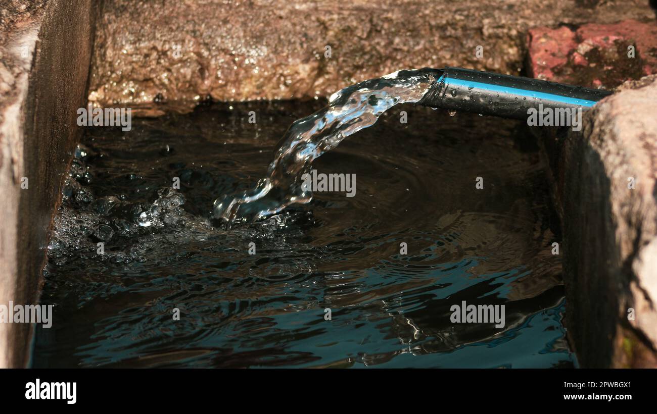 flusso d'acqua sul tubo e scarico al serbatoio dell'acqua Foto Stock